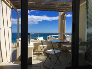 a balcony with a table and chairs and the ocean at El Ático de Carboneras in Carboneras
