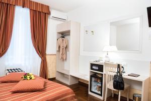 um quarto com uma cama, uma secretária e uma cómoda em Domus Giulia em Roma