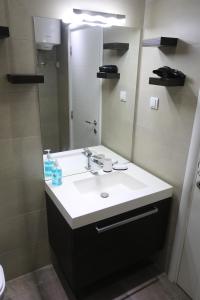 un bagno con lavandino e specchio di De Luxe Republic Square Apartment of 100sqm a Belgrado Altre 28 foto
