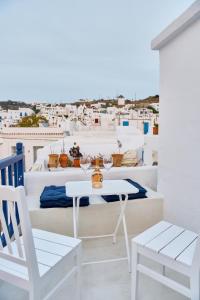 a white table and chairs on a balcony with white buildings at Blanco Rooms Mykonos in Mikonos