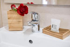 eine Küchentheke mit einer Spüle mit einer Blume neben einem Wasserhahn in der Unterkunft Domus Giulia in Rom + 34 Fotos