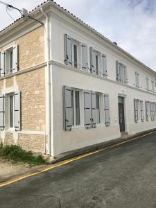 un bâtiment blanc avec des fenêtres sur le côté d'une rue dans l'établissement La Charentaise, à Saint-Palais-sur-Mer