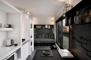 un soggiorno con divano in una piccola camera di Mini Loft ULB DELTA area with terrace a Bruxelles
