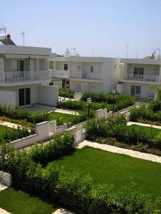 un grande edificio con un cortile con erba e cespugli di Casa Alice Vista Mare a Marina di Ragusa