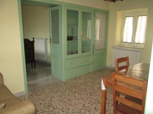 uma sala de estar com um armário verde e uma mesa em Casa e Putia em Gangi