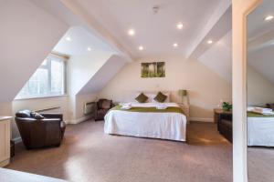 a attic room with a bed and a chair at The Limes Country Lodge Hotel & Admiral Restaurant in Solihull