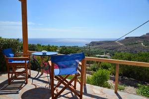 two chairs and a table on a balcony with a view at Anthia Apartment Sea View in Kato Zakros