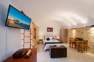 - une chambre avec un lit et une télévision murale dans l'établissement Emerald Dream House, à Rhodes