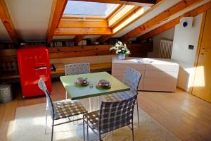 a kitchen with a table and chairs and a red refrigerator at Suite Ananda in Verbania