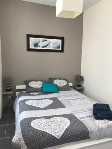 1 dormitorio con 1 cama con manta blanca y negra en La Charentaise, en Saint-Palais-sur-Mer