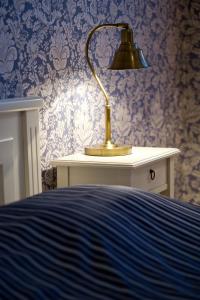 a lamp sitting on a table next to a bed at Hotell Krabban in Strömstad