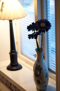 a vase with flowers sitting on a table next to a lamp at Hotell Krabban in Strömstad