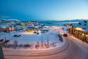 a town in the snow with a street and buildings at F2 Hotel in Harstad