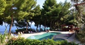 a swimming pool in a resort with trees at Evripidis Hotel in Afitos