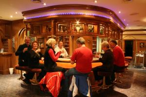 un grupo de personas sentadas en un bar en Hotel Tiroler Adler Bed & Breakfast, en Waidring