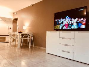 ein Wohnzimmer mit einem Flachbild-TV auf einem weißen Schrank in der Unterkunft Apartamenty Aleksandry Apartament przy Parku in Świnoujście