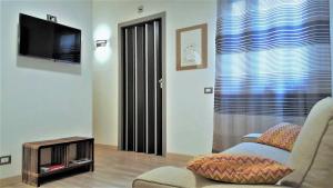 a living room with a tv and a couch and a chair at NoMapartments Il Cortile Romey in Trapani