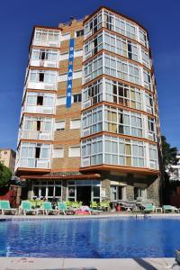 a tall building with a pool in front of it at Apartamentos Doramar in Benalmádena