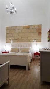 a bedroom with a large bed and a chandelier at NoMapartments Il Cortile Romey in Trapani