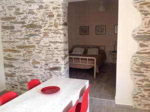 Habitación con mesa, cama y pared de piedra. en George Home 1 en Balíon