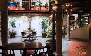 a patio with tables and chairs and plants in a building at La Casona de la Ronda Hotel Boutique in Quito