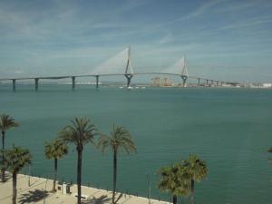 eine Brücke über einen großen Wasserkörper mit Palmen in der Unterkunft Bay Home in Cádiz