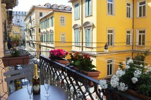 einen Balkon mit einem Tisch mit Weingläsern und Blumen in der Unterkunft EVA affittacamere in La Spezia