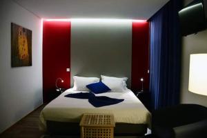 a bedroom with a bed with blue pillows on it at OHStudios in Oliveira do Hospital
