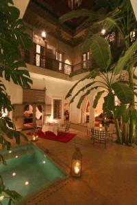 a large house with a swimming pool in a courtyard at Riad Altair in Marrakesh