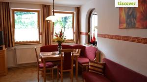 comedor con mesa, sillas rojas, mesa y sillón en Ferienhaus Fabio en Thürnthal