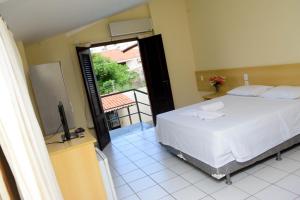 1 dormitorio con 1 cama grande y balcón en Hotel Sambaquis en São Luís