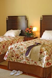 a hotel room with two beds with shoes on the floor at Quinta das Merces in Angra do Heroísmo