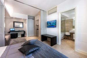 a bedroom with a bed and a bathroom at Hotel Porta Reale in Noto