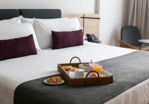 a tray of breakfast food on a bed at Dazzler by Wyndham Rosario in Rosario
