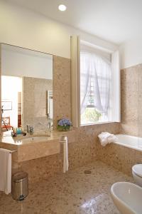 ein Badezimmer mit einer Badewanne, einem Waschbecken und einem Spiegel in der Unterkunft Quinta das Merces in Angra do Heroísmo