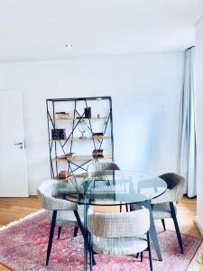 ein Esszimmer mit einem Glastisch und Stühlen in der Unterkunft Oporto Chic&Cozy - S. Bento in Porto