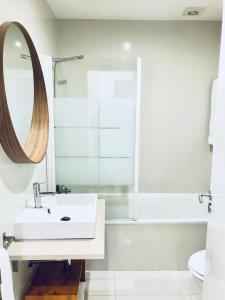 ein Badezimmer mit einem Waschbecken, einer Badewanne und einem Spiegel in der Unterkunft Oporto Chic&Cozy - S. Bento in Porto