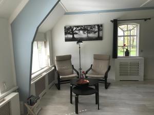 sala de estar con 2 sillas y mesa en Bed en Breakfast de Houtwiel, en De Valom