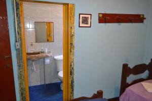 een badkamer met een wastafel, een toilet en een spiegel bij Pouso da Passagem B&B in Mariana