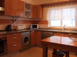 a kitchen with a washing machine and a microwave at Europa Beach House in Manta Rota
