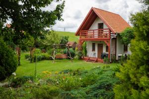 mały dom z ogrodem i huśtawką w obiekcie Domki letniskowe "Pod lipą" w mieście Zełwągi