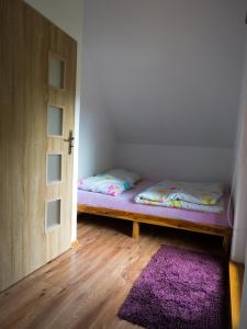 Un pat sau paturi într-o cameră la Domki letniskowe "Pod lipą"