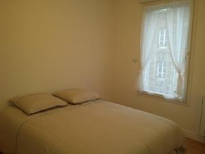 ディエップにあるMaison de ville Dieppeの窓付きのベッドルームに枕2つ付きのベッド1台が備わります。