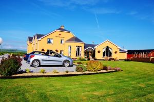 um carro estacionado em frente a uma casa amarela em The 19th Golf Lodge em Ballybunion