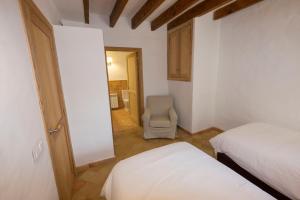 a bedroom with a bed and a chair in a room at Agroturismo Son Alzines in Lluc