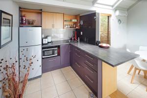 a kitchen with purple cabinets and a counter top at Palm Waiheke Island Resort in Palm Beach