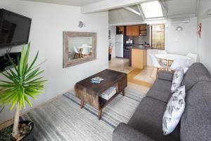 a living room with a couch and a table at Palm Waiheke Island Resort in Palm Beach