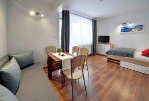 Televízia a/alebo spoločenská miestnosť v ubytovaní Apart-Invest Apartament Słoneczny Poranek