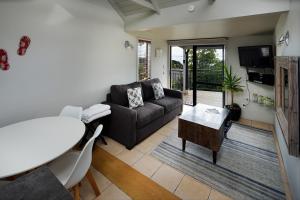 a living room with a couch and a table at Palm Waiheke Island Resort in Palm Beach