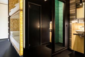 Łazienka z czarnymi drzwiami i umywalką w obiekcie Bastardo Hostel w Madrycie